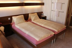 A double bed with a wooden headboard and a nightstand with a lamp. - Hotel Glv Rnisch Hof (Horgen)
