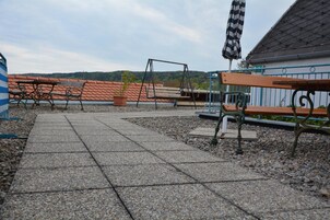 Un sendero pavimentado con bancos y un parque infantil.