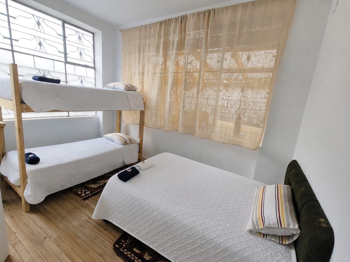 Un dormitorio con literas, una ventana con vistas y una cortina.