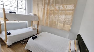 Un dormitorio con literas, una ventana con vistas y una cortina.