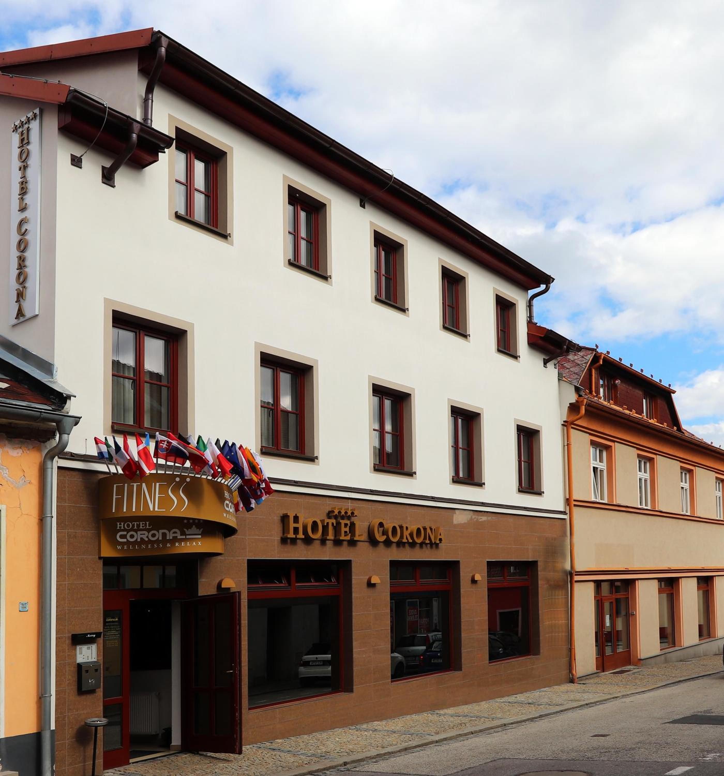 Ein Hotelgebäude mit vielen Fenstern und einem Schild mit der Aufschrift 'Hotel Corona'.