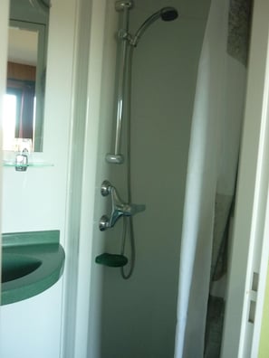 A bathroom with a shower, a sink, and a mirror. - Hotel Restaurant La Chaumiere Du Lac (Clairvaux-les-Lacs)