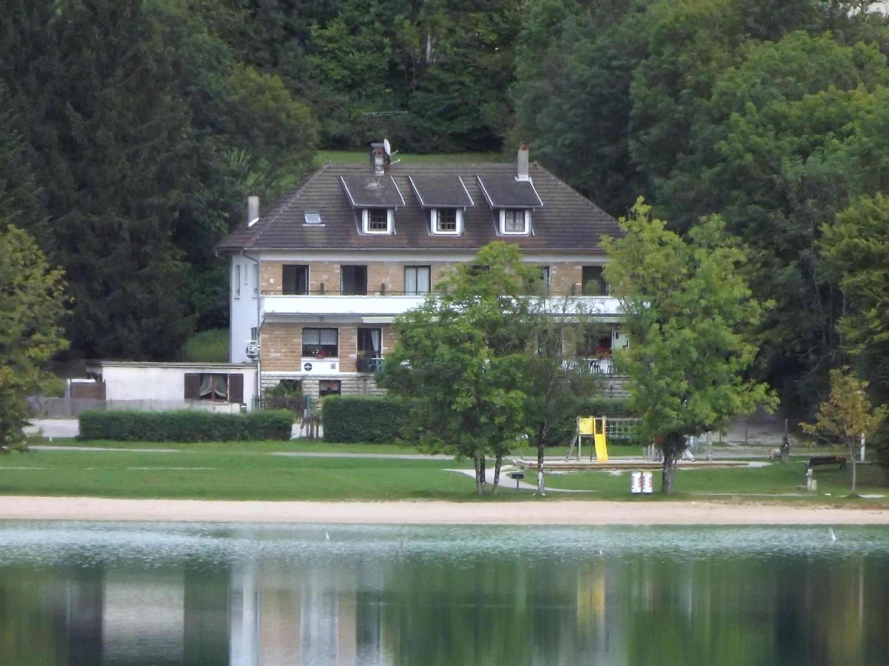 A two-story house with a sloped roof, a visible chimney, and a satellite dish.