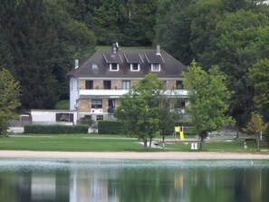 A two-story house with a sloped roof, a visible chimney, and a satellite dish. - Hotel Restaurant La Chaumiere Du Lac (Clairvaux-les-Lacs)