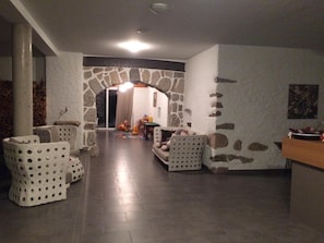 Un vaste espace de vie agrémenté d’un mur en pierre, d’un canapé et d’une table basse.