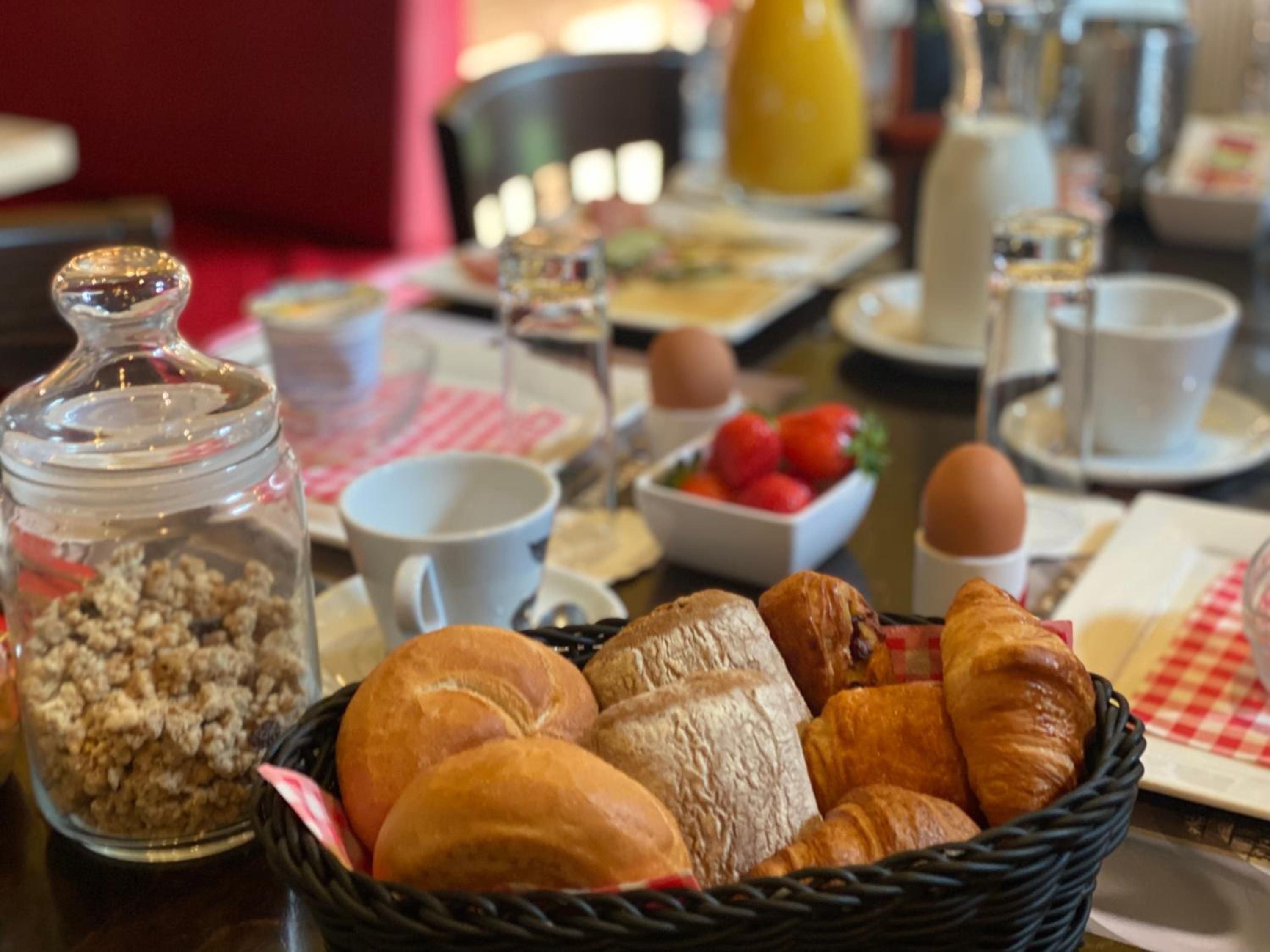 Et morgenbord med brød, æg og en skål med frugt.