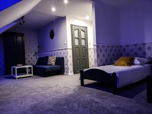 A bedroom with a bed, a sofa, a small table, and a door. - Hotel Tara (Kielce)
