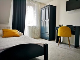 Un dormitorio con cama, armario, escritorio y silla.