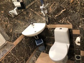 Un baño con lavamanos blanco, inodoro y espejo.
