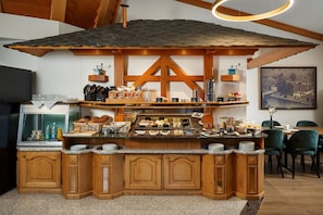 A breakfast bar with a rustic wooden design, equipped with various food items and beverages. - Hotel An Der Reuss (Gisikon)