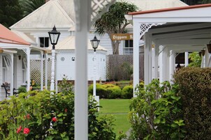 A white building with a sign reading 'Diggers Rd.' and a covered outdoor area with a white fence and greenery.
