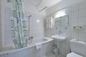 Un baño moderno con bañera, lavamanos e inodoro.