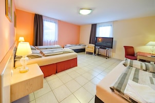 Una habitación de hotel con dos camas, televisión, escritorio y una silla.