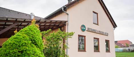 Een gebouw met twee verdiepingen, met een bord waarop een restaurant aangegeven staat.