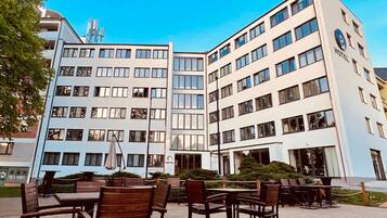 Un hotel de varios pisos, con terraza exterior y cielo despejado.