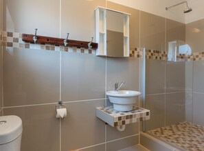 A bathroom with a toilet, sink, and shower.