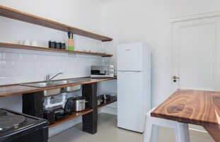 Cocina compacta con horno integrado, microondas y refrigerador.