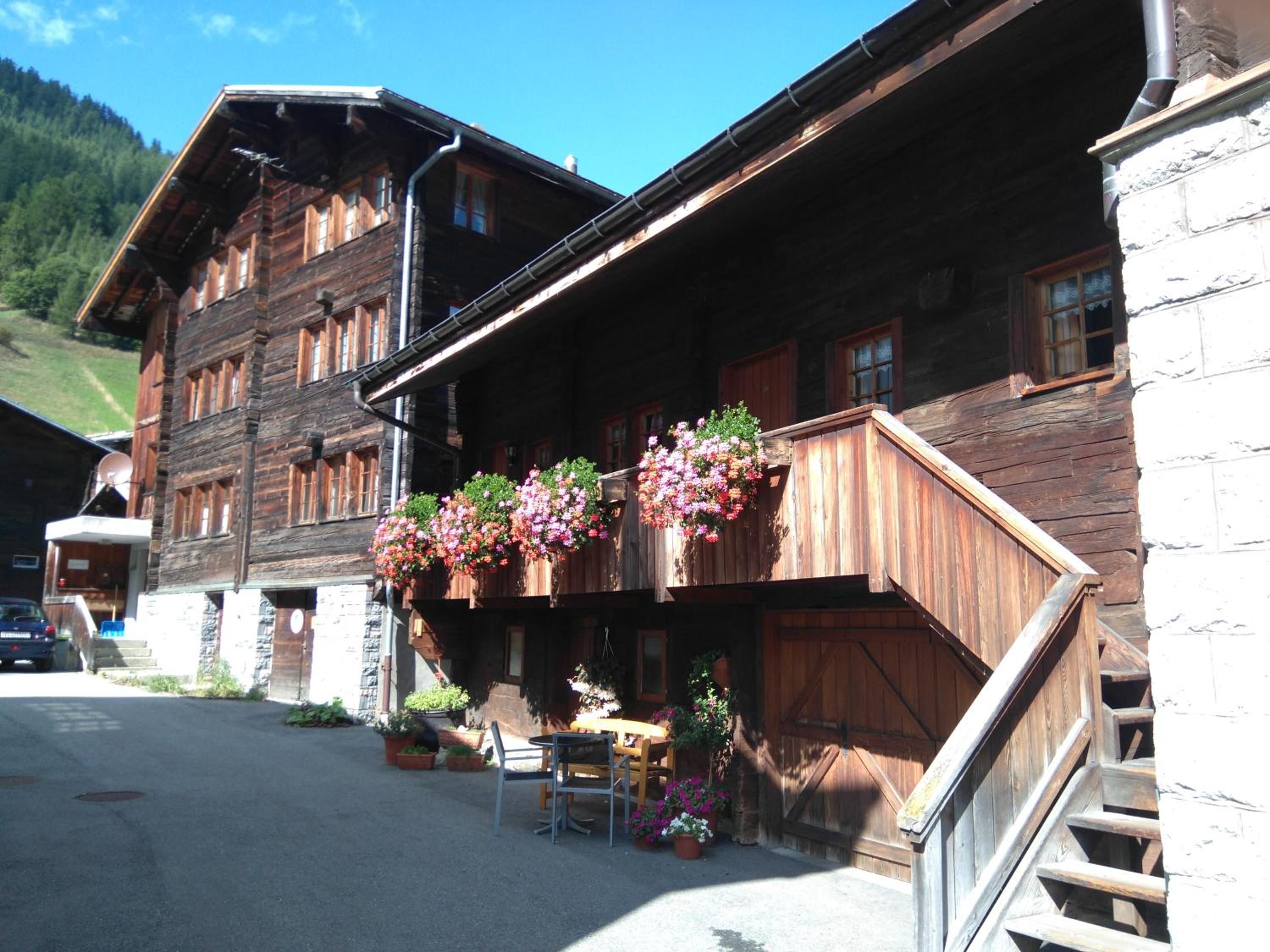 A wooden building with a balcony adorned with hanging flower baskets.