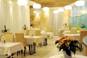 A restaurant with tables and chairs, a decorative wall, and a potted plant. - Falken Am Rotsee (Ebikon)