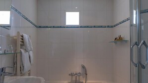 Un baño con bañera, lavabo y cabina de ducha de vidrio.