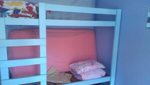 Uma cama beliche com colchão e travesseiros cor-de-rosa.