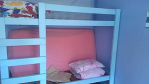 Una cama litera con colchón y almohadas rosadas.