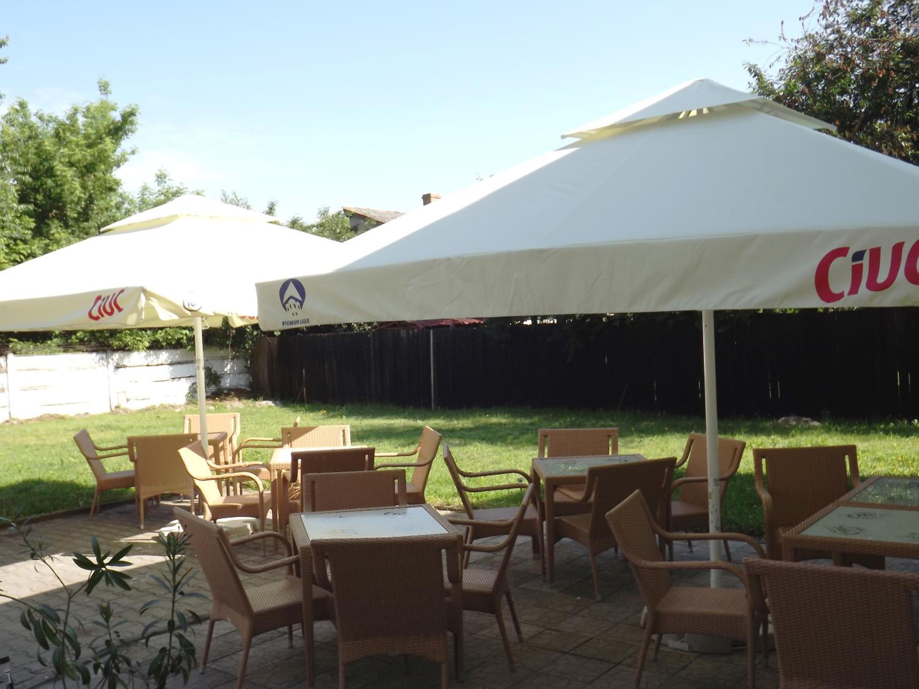 An outdoor patio area with wicker furniture and white canopies.