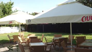 An outdoor patio area with wicker furniture and white canopies.