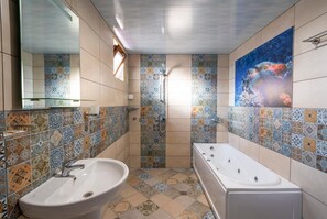 Un baño con una bañera grande, un lavabo y una ducha. Las paredes están revestidas con un diseño estampado.