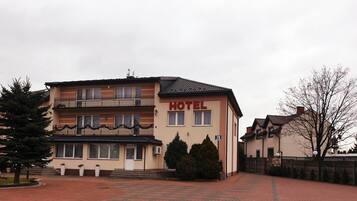 A hotel with a two-story structure, a balcony on the upper floor, and a sign indicating the address as 70.