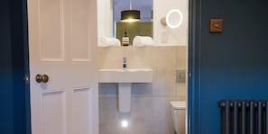 A bathroom with a white sink, a mirror, a towel, and a toilet. - Purchases Restaurant Accommodation (Chichester)