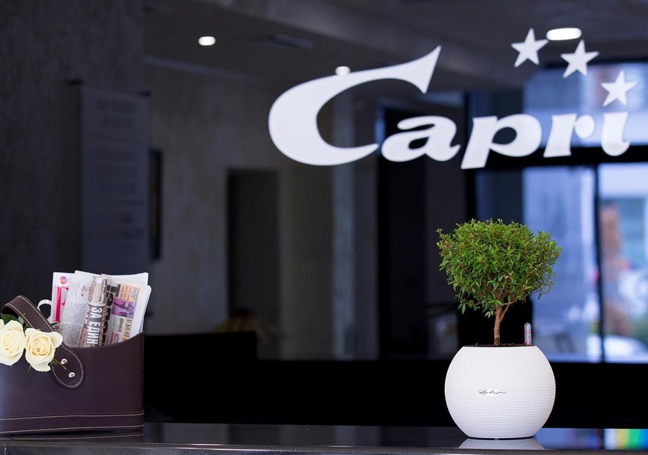 A reception desk with a sign reading 'Capri' and a potted plant.