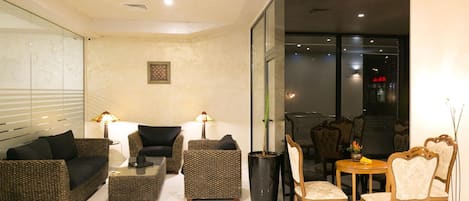 A modern living room with a sofa set, a coffee table, and a dining area with chairs.