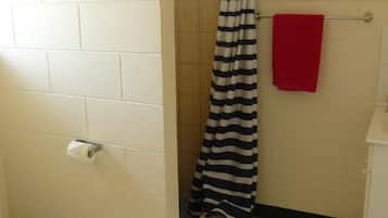 A bathroom with a shower, a toilet, and a towel rack.