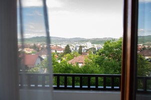 Vista desde una ventana sobre un pueblo con edificios y zonas verdes.