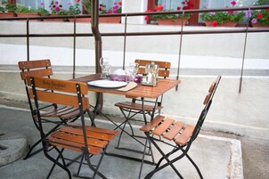 Una mesa de madera con cuatro sillas, un plato blanco y una caja de pañuelos.