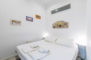 A hotel room with a bed, two towels, and three wall-mounted pictures. - A Storia (Syracuse)
