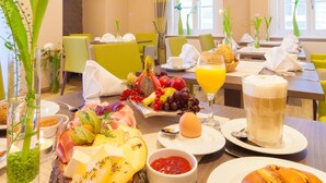 A breakfast setting with a variety of food items, including fruits, bread, and a glass of orange juice. - Gda Hotel Schwiecheldthaus (Goslar)