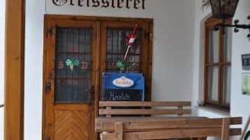 A wooden bench outside a building with a sign reading 'Breisslerei'.