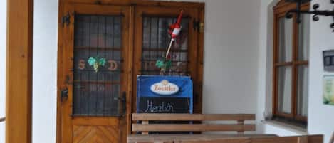 A wooden bench outside a building with a sign reading 'Breisslerei'.
