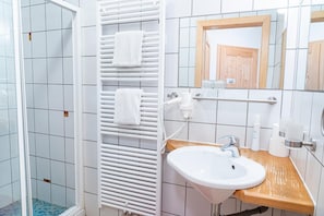 A bathroom with a white sink, a mirror, and a towel rack. - Gasthof Diewald (Raach am Hochgebirge)
