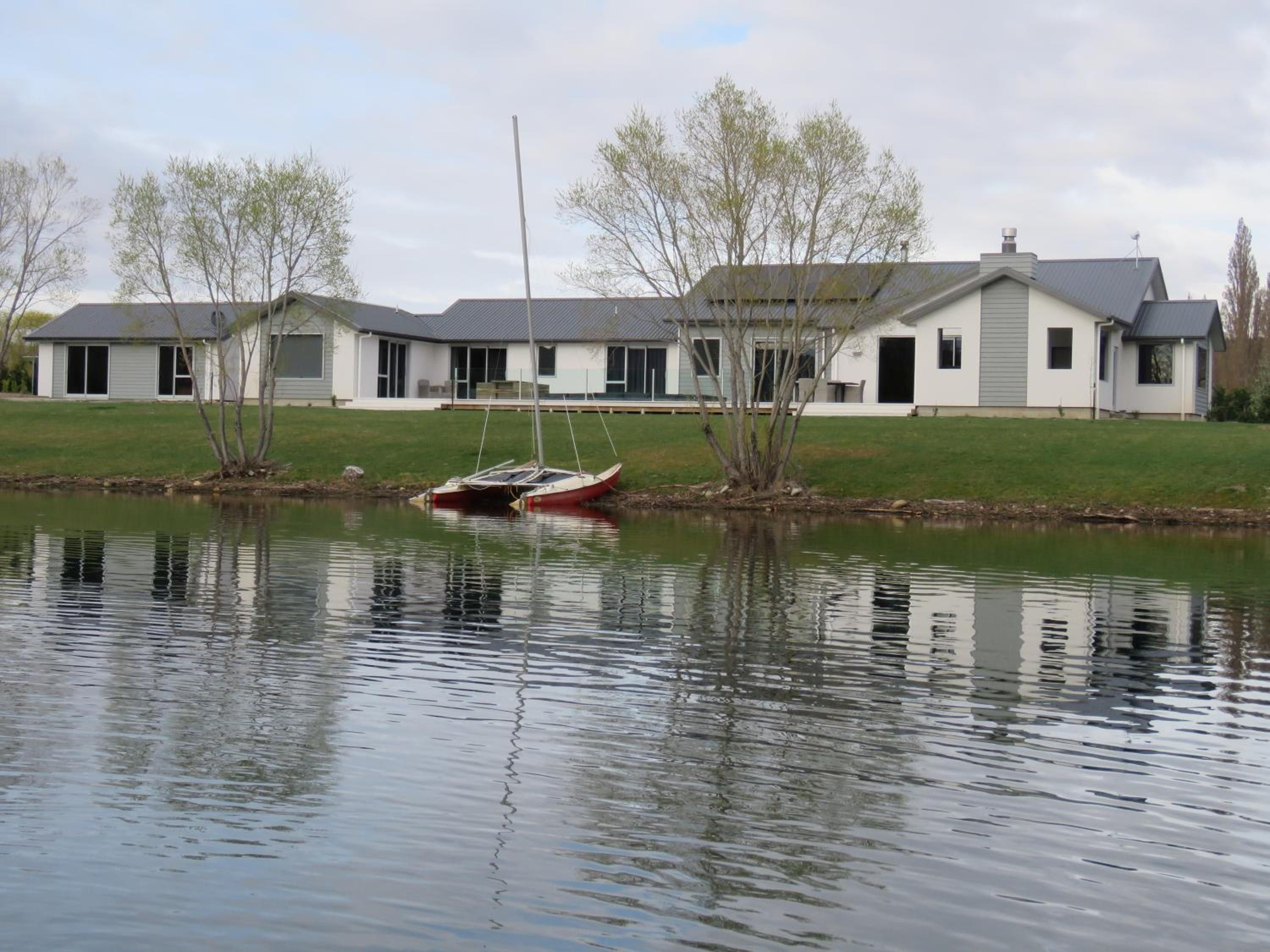 A lakeside property with a house, a dock, and a calm water body.