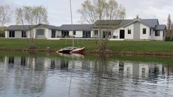 A lakeside property with a house, a dock, and a calm water body.