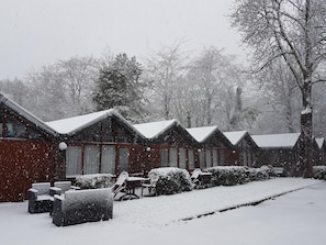 A row of cabins with snow-covered roofs and a snow-covered lawn. - Motel Oostvoorne (Oostvoorne)