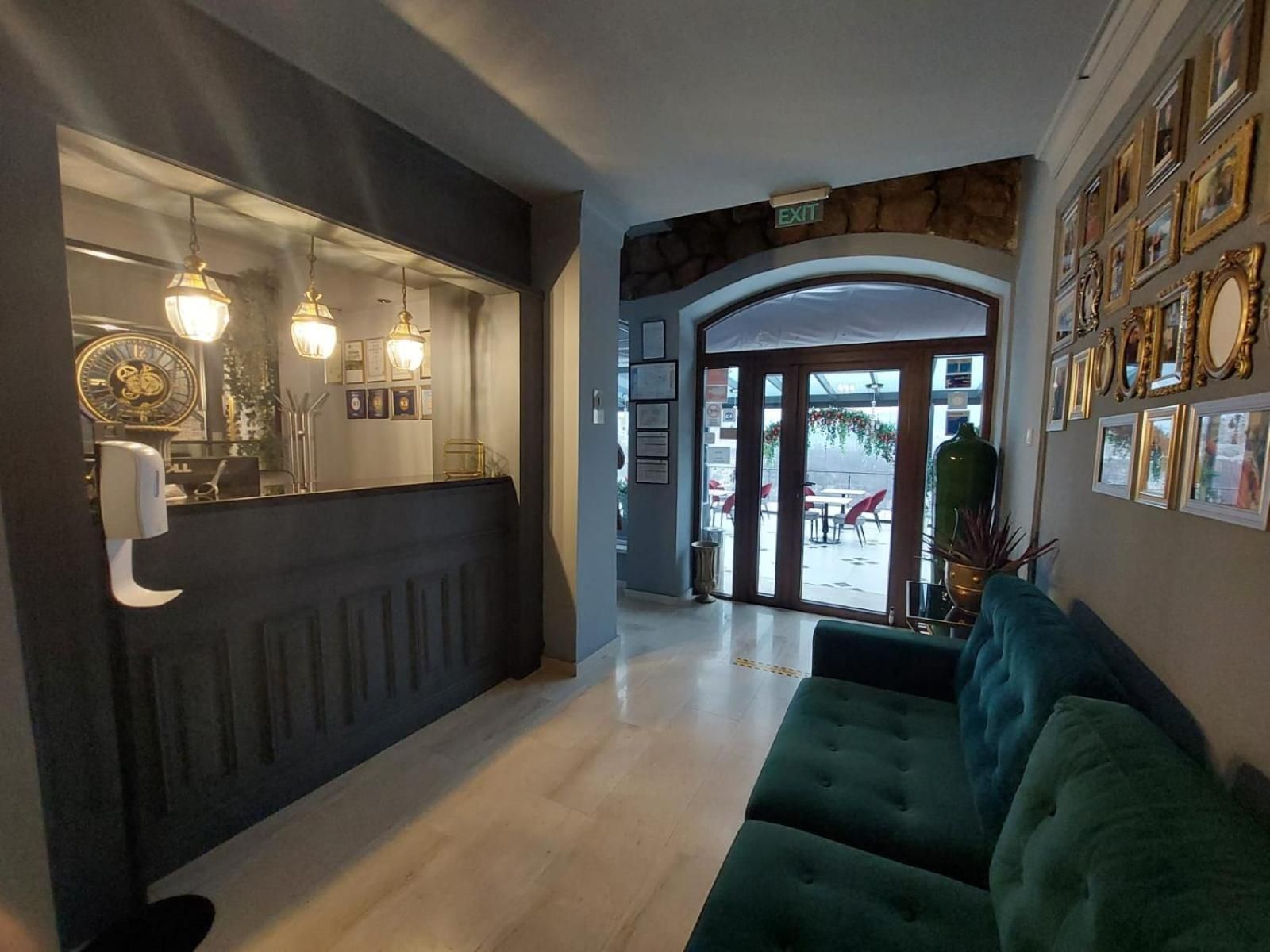 A reception area with a counter, wall-mounted lights, and framed certificates.