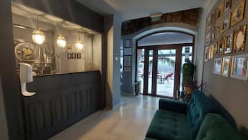 A reception area with a counter, wall-mounted lights, and framed certificates.