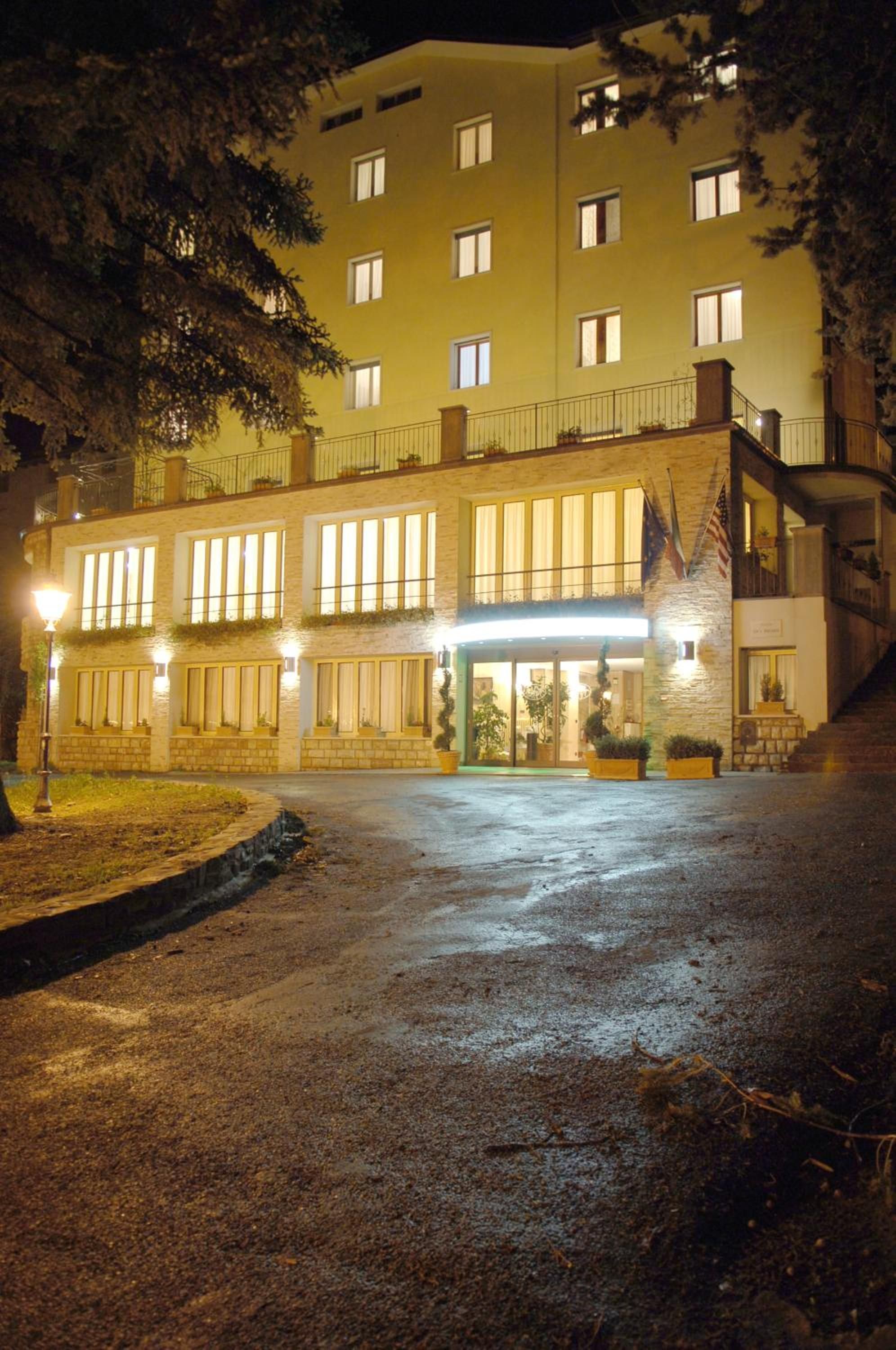 A multi-story hotel with a central entrance, large windows, and a stone facade.