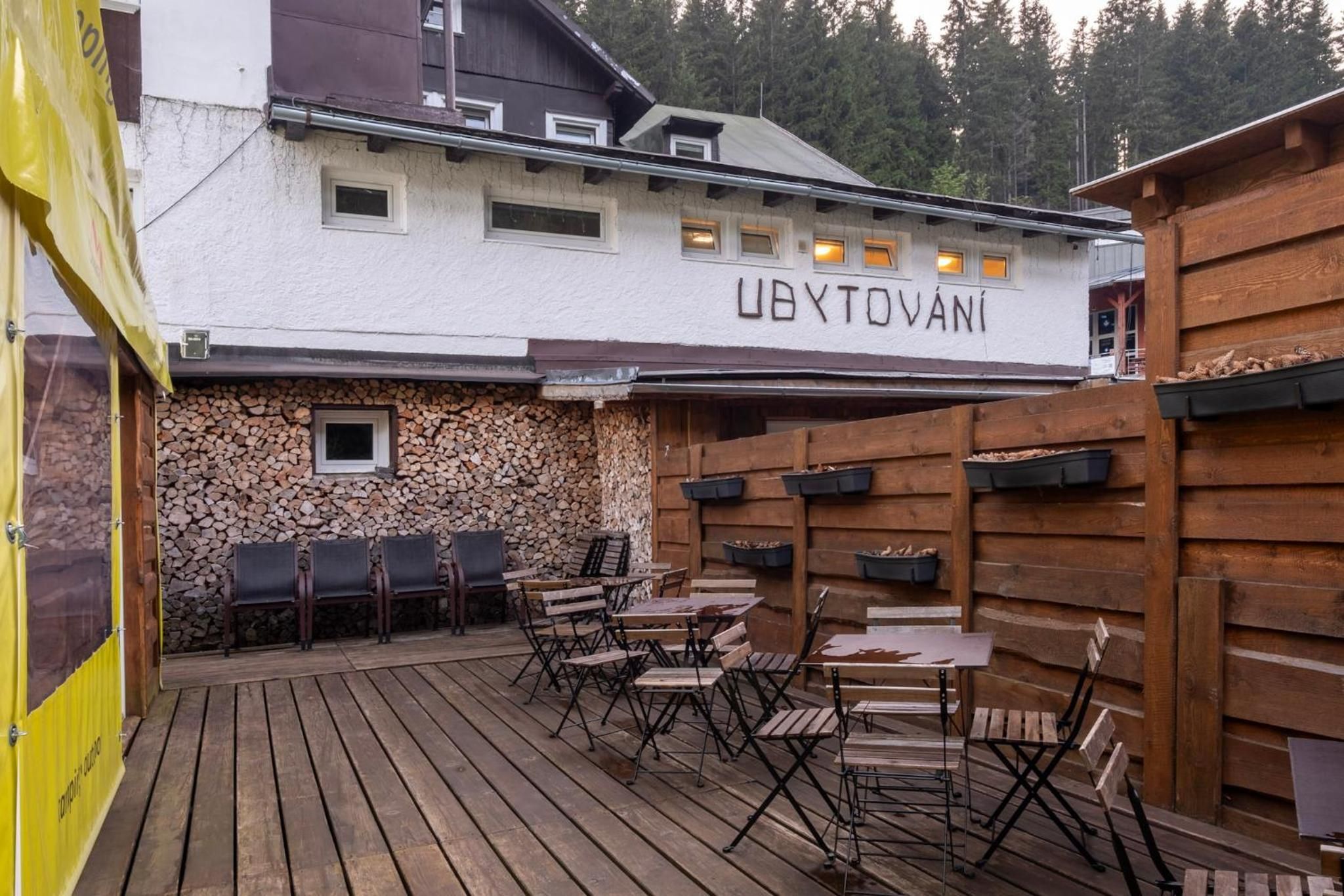 A wooden deck with outdoor seating and a stone wall.
