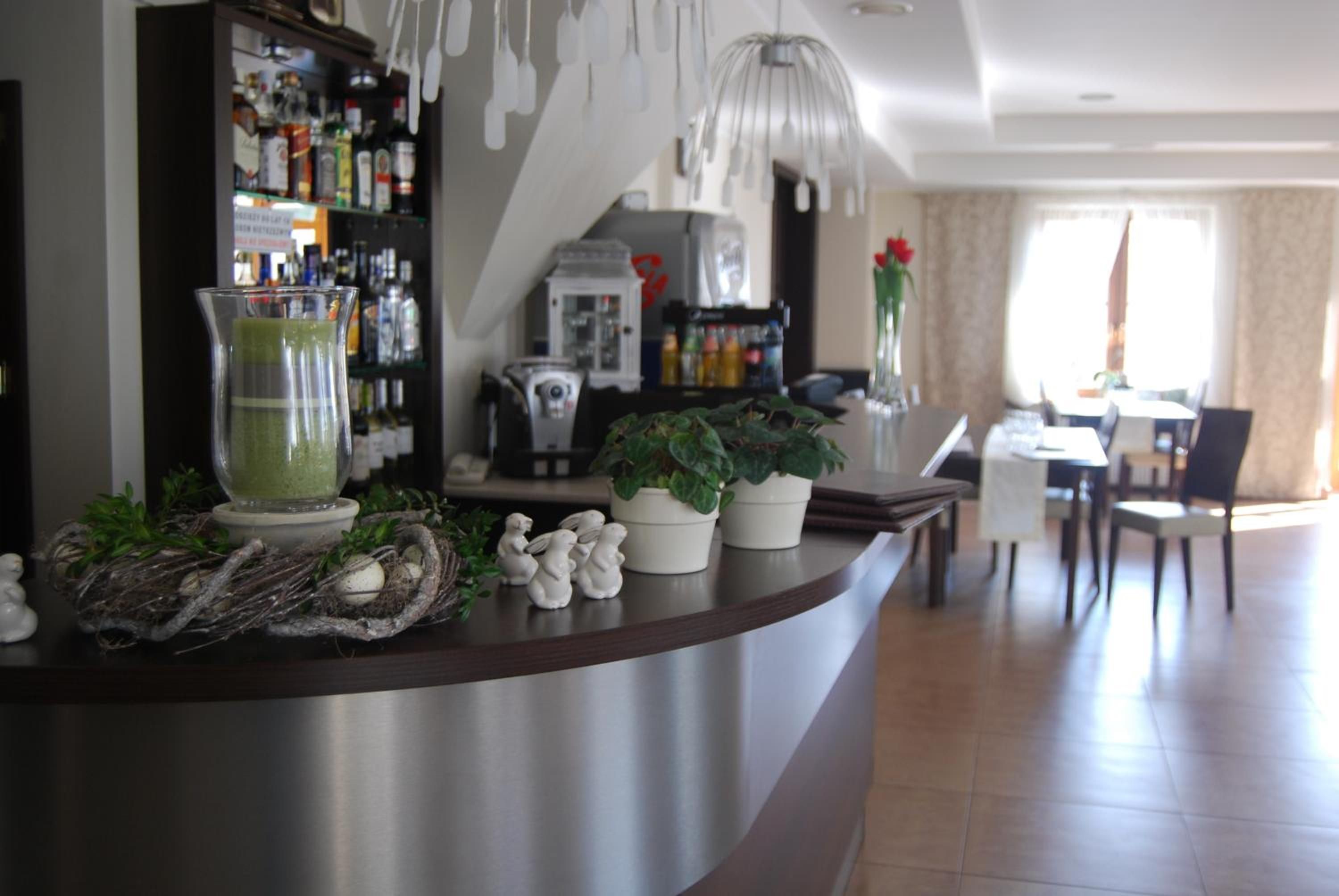 A bar area with a drink dispenser, a coffee machine, and a potted plant.