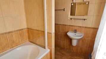 Un baño con bañera, lavamanos y ducha.